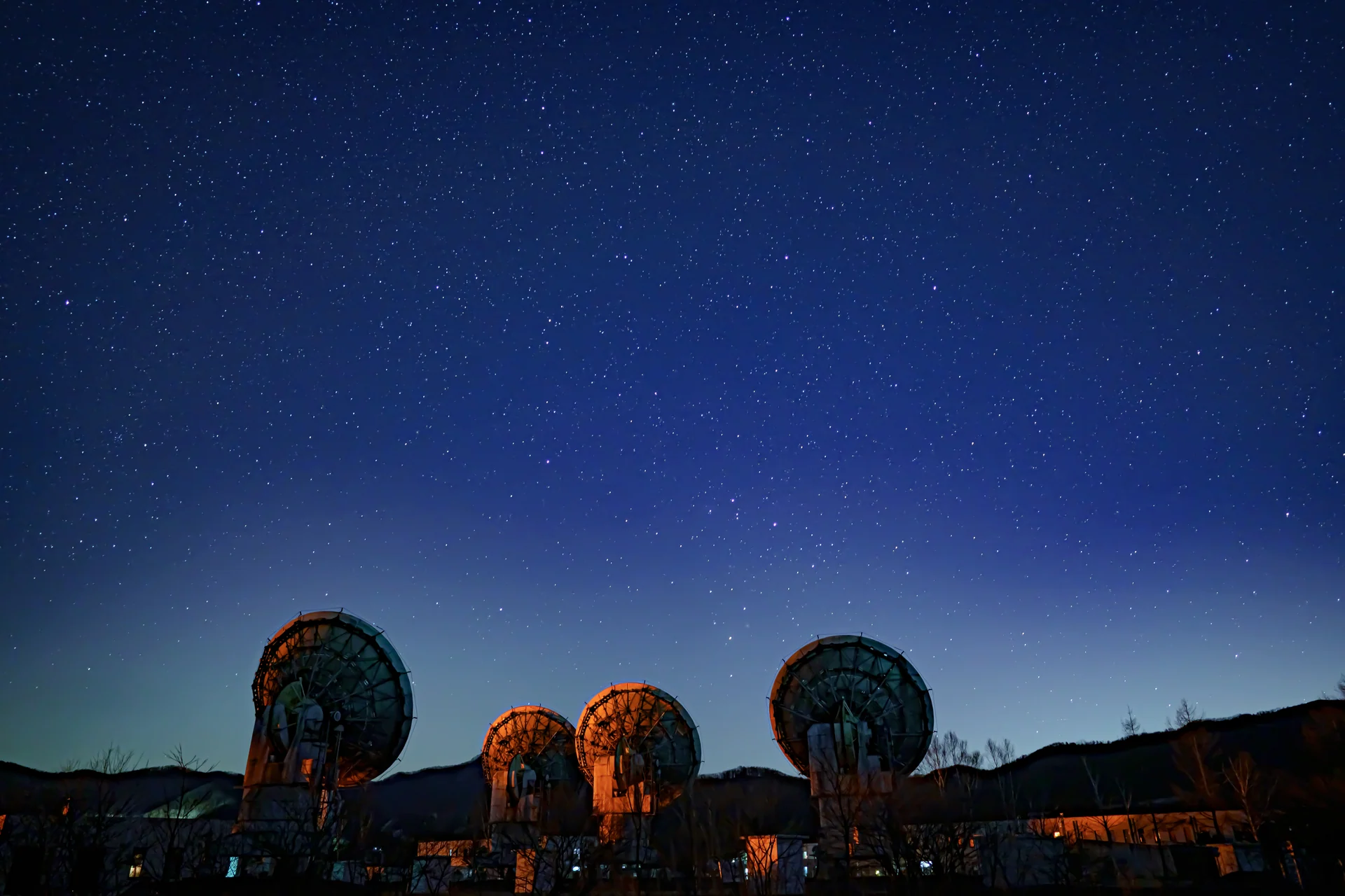 野辺山高原で星空を背景に並ぶ電波望遠鏡