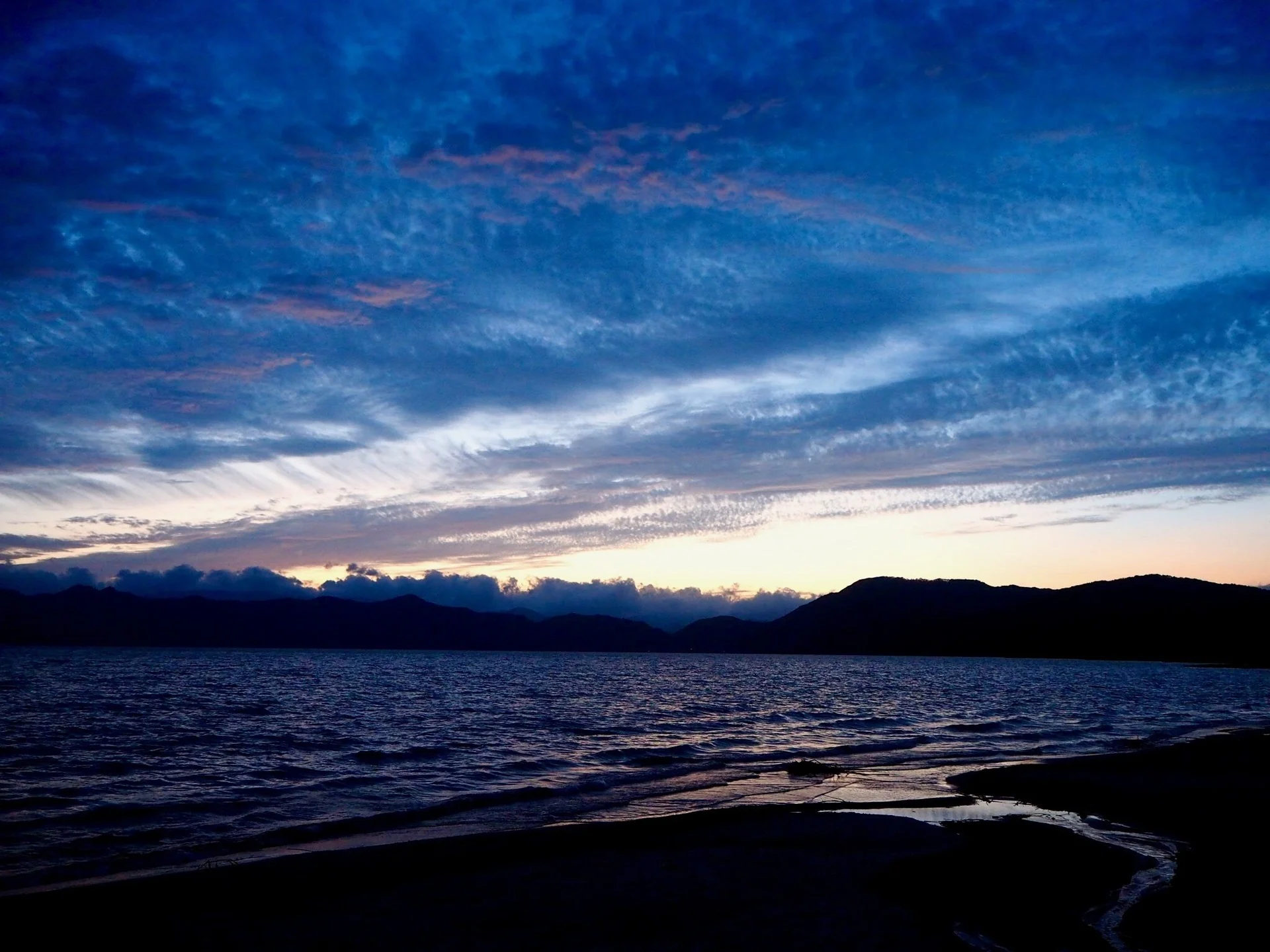 夕方の空と山が静かな湖面に映る田沢湖