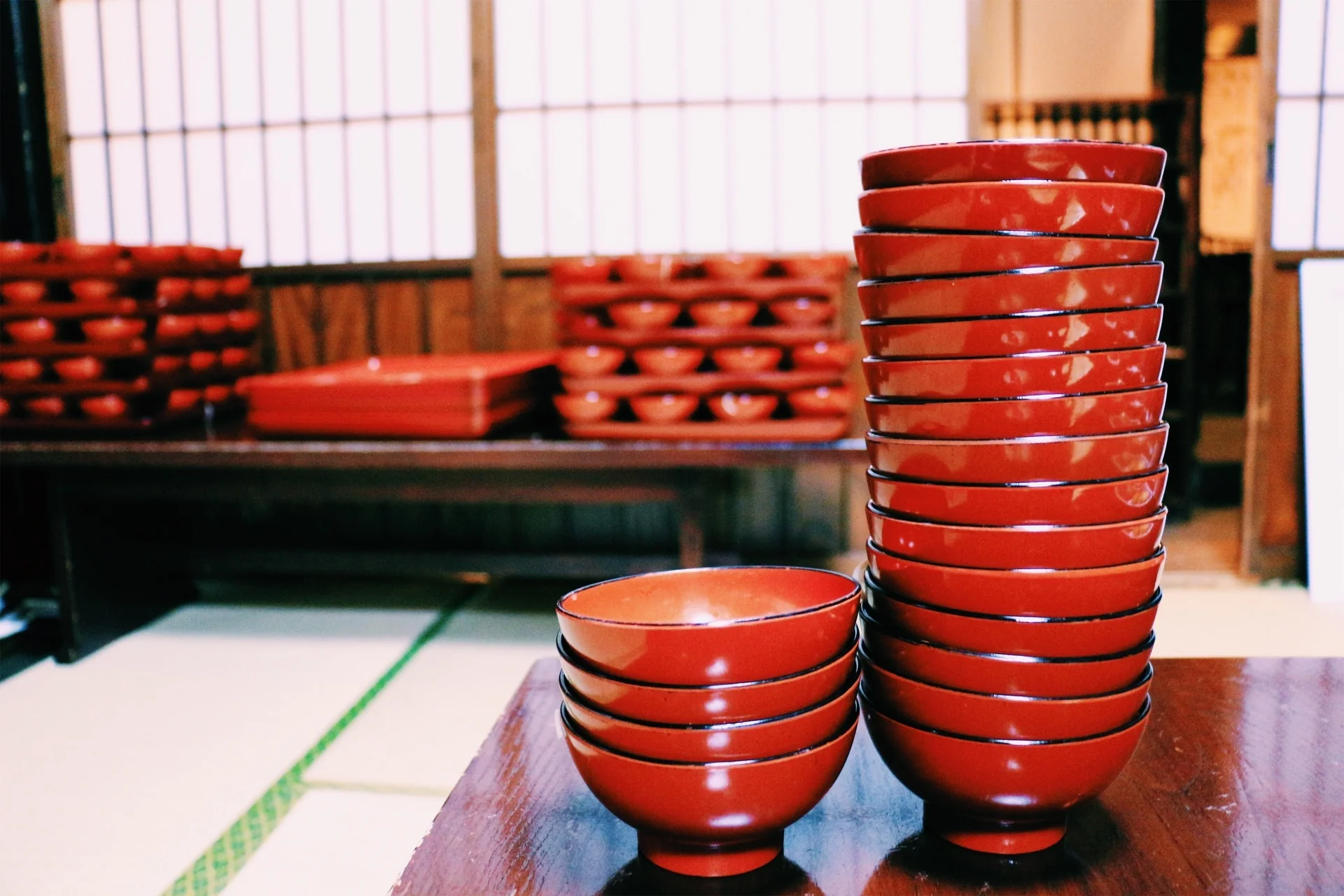 座敷の卓上に高く重ねられた、わんこそばの赤い椀