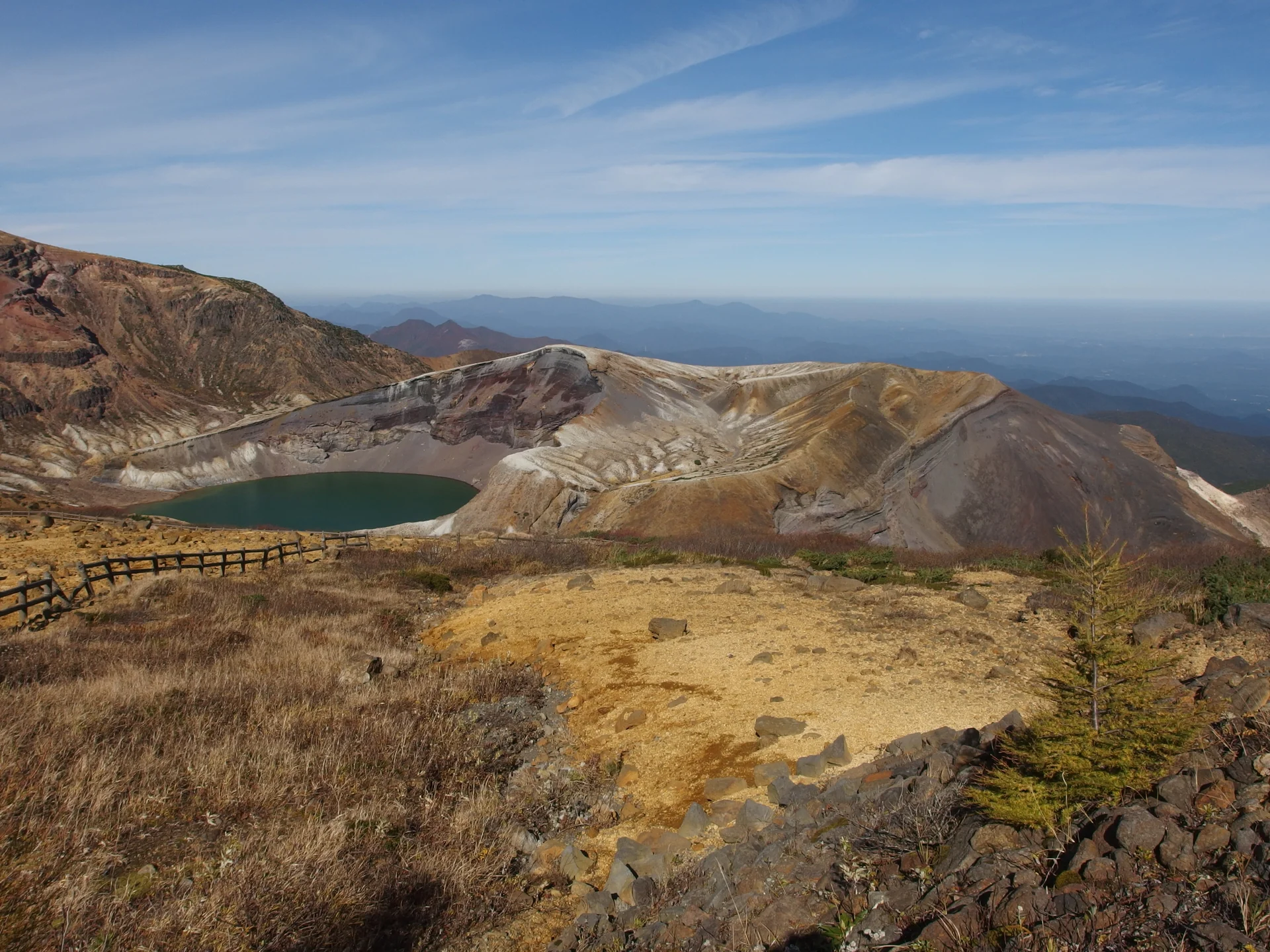 火口壁に囲まれた蔵王御釜の湖面と山岳景観