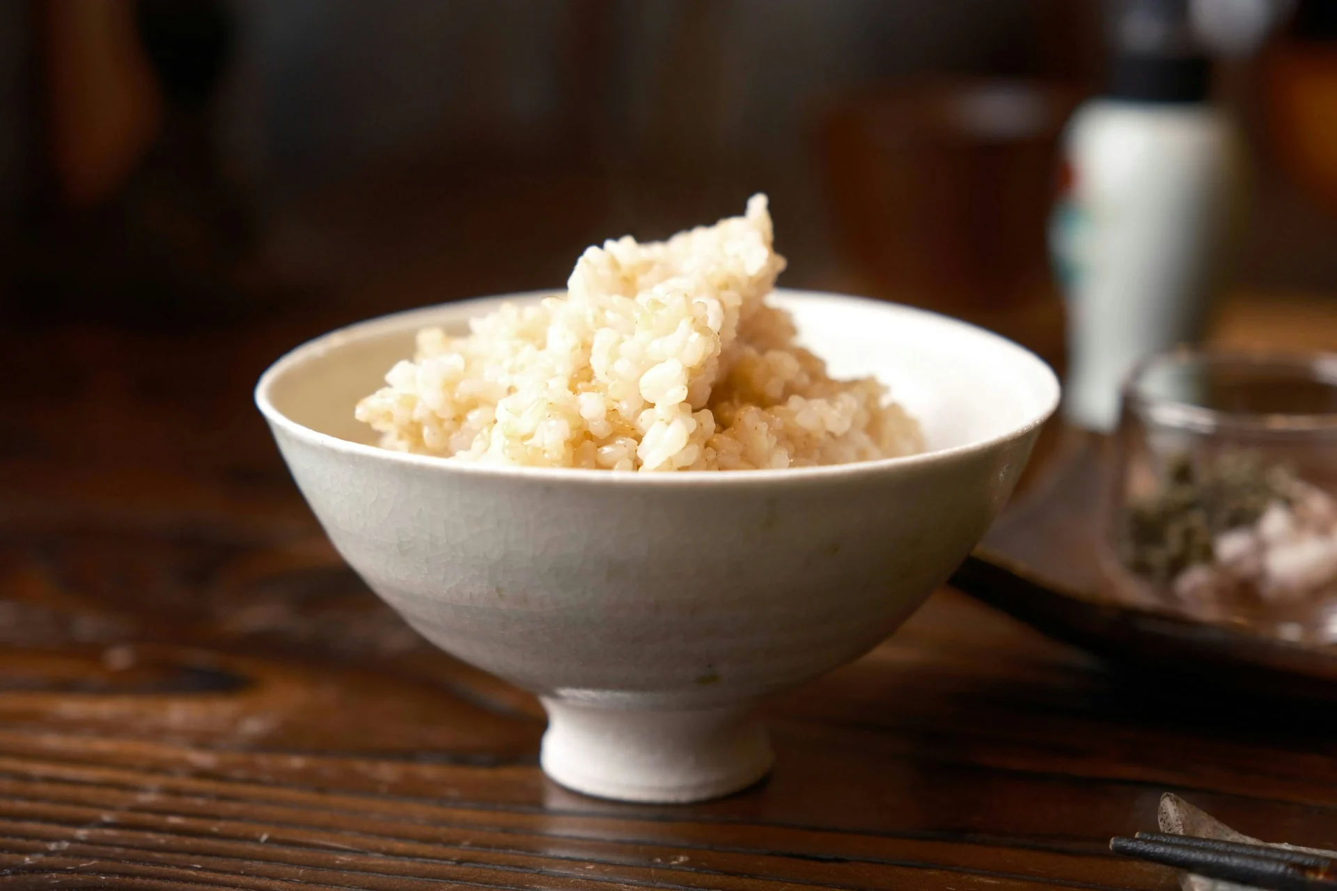木のテーブルに置かれた茶碗のご飯