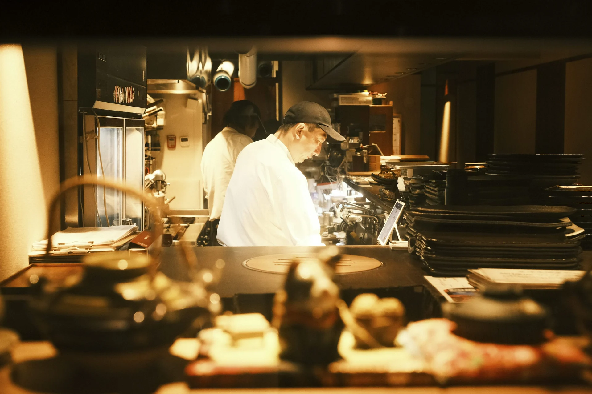 飲食店の厨房で並んで作業する調理人